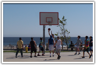 Guys playing basketball on the beach